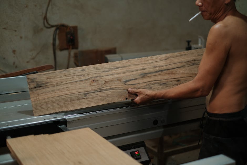 A carpenter in a workshop cuts wood with precision, showcasing craftsmanship.